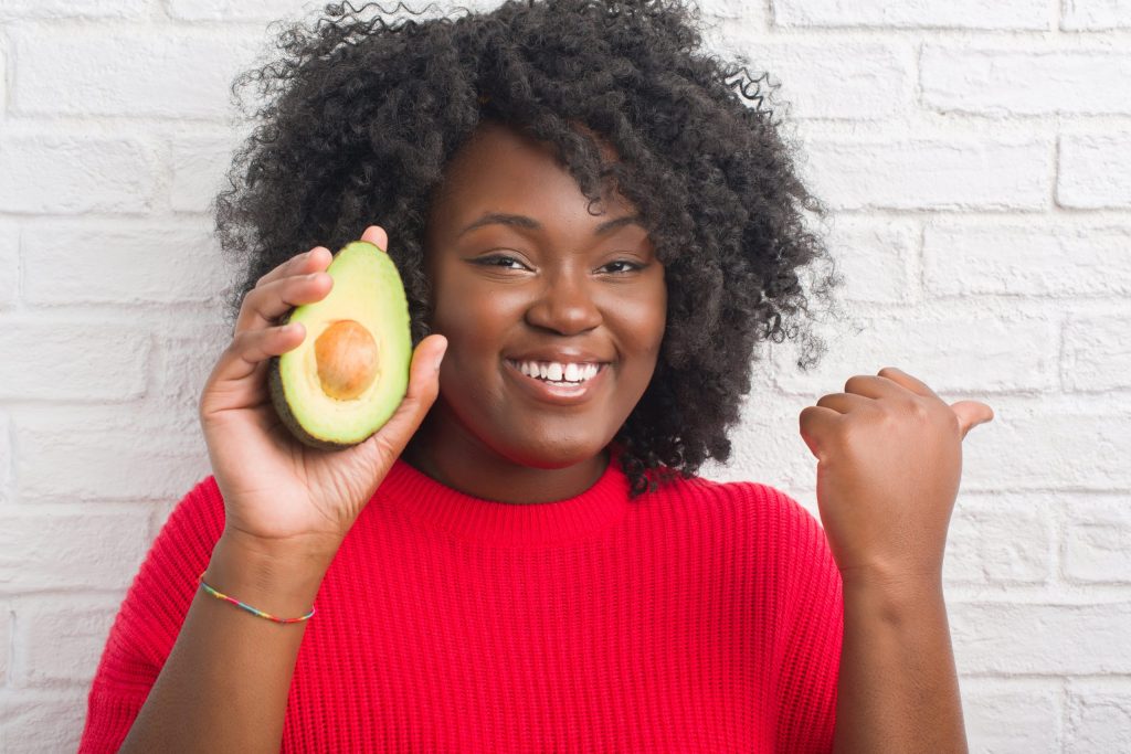 woman holding an avocado