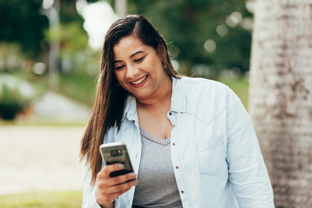 happy plus size woman looking at phone