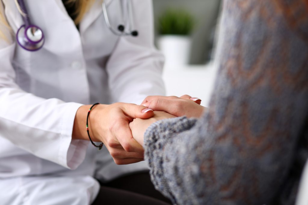 Friendly female doctor hold patient hand