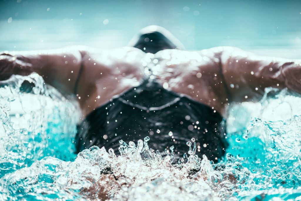 Butterfly stroke swimmer from back